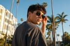 Model wearing HONCHO sunglasses, gold frame with black accents, LA street style